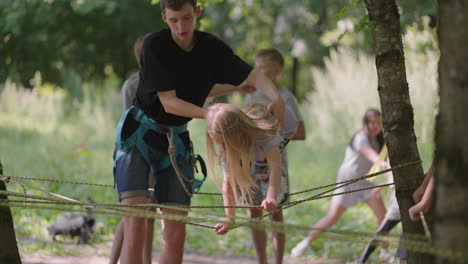 In-the-summer-camp-my-daughter-learns-to-overcome-rope-obstacles-and-rock-climbing.-Teaching-children-about-tourism-and-hiking
